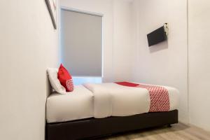 Postel nebo postele na pokoji v ubytování Hotel O Metropolitan Homestay Near Komplek Asia Megamas Medan