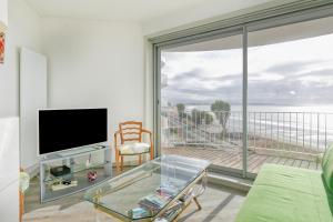 a living room with a large window with a view of the ocean at Pieds dans l'eau - Balcon vue mer in La Baule