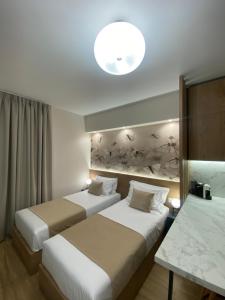 a hotel room with two beds and a light fixture at Nebula Apartments in Tirana +128 photos