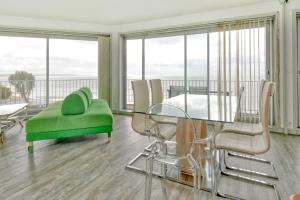 a dining room with a glass table and chairs at Pieds dans l'eau - Balcon vue mer in La Baule