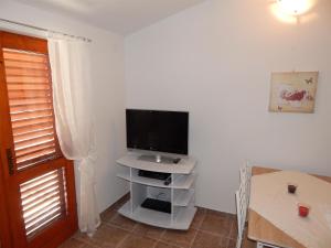 a living room with a flat screen tv on a stand at Apartment Matilda in Starigrad