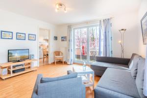 a living room with a couch and a tv at Helle Fewo in toller Lage mit Badewanne und Balkon in Kühlungsborn