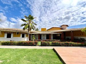 a house with a palm tree in front of a yard at Casa Mares in Estância