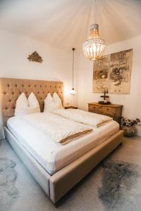 a bedroom with a large bed and a chandelier at K-Style Chalet Premium-Twin-Lofts with private Sauna in Mieders