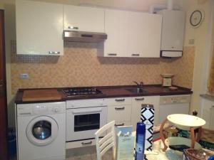 a kitchen with white cabinets and a washing machine at Appartamento Via Adriatica Nord in Cupra Marittima