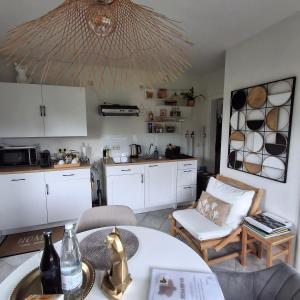 a kitchen with white cabinets and a table and chairs at Le Renard'or in Trois-Ponts +43 photos