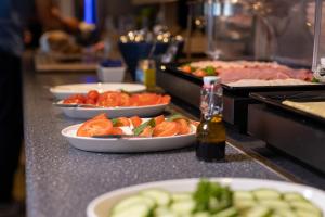 un buffet con piatti di cibo su un bancone di Strandhotel Buren aan Zee a Buren