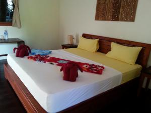a bedroom with a large bed with red decorations on it at Lucky Gecko Garden in Ko Chang
