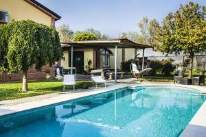 a swimming pool with two chairs and a house at Oasi del Po in Monticelli dʼOngina