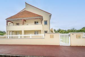 a house with a white fence and a balcony at la terrasse de Landouge in Limoges