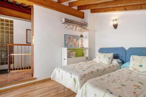 a bedroom with two beds and a window at Casa calle del Carmen in Grazalema
