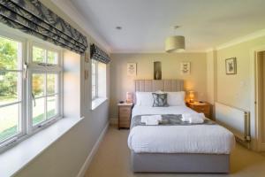 a bedroom with a large bed and two windows at Westgate Cottage T 4 in Thornham