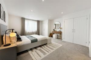 a white bedroom with a large bed and a mirror at River Breeze 3-Bed BALCONY Apartment in Littlehampton