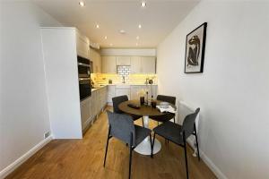 a kitchen and dining room with a table and chairs at River Breeze 3-Bed BALCONY Apartment in Littlehampton