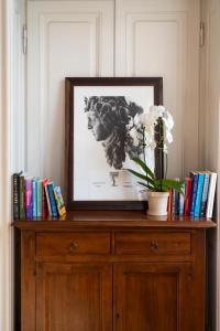 a picture on top of a wooden cabinet with books at Boboli Living in Florence