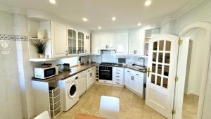 a kitchen with white cabinets and a stove top oven at 2 bedrooms with swimming pool Nomad Dreams N 7 in Cascais