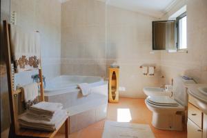 a bathroom with a tub and a toilet and a sink at Suíte Private balcony Hot Tub in Aguda +20 photos