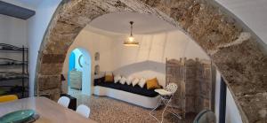 a bedroom with a bed in a room with a stone wall at Maison de village Mona in Sellía