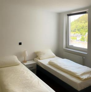 zwei Betten in einem Zimmer mit Fenster in der Unterkunft FeWo 26 in Willingen