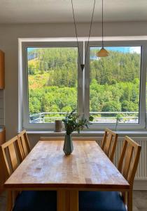 ein Esstisch mit einer Vase mit Blumen darauf in der Unterkunft FeWo 26 in Willingen
