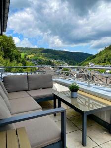 ein Sofa und einen Tisch auf dem Balkon in der Unterkunft FeWo 26 in Willingen