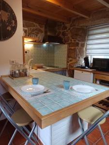 a kitchen with a counter with two sinks in it at O lar de Cabanas in Brion +10 photos