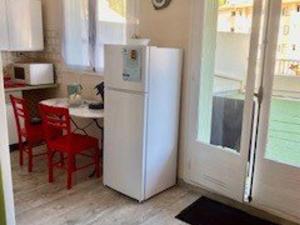białą lodówkę w kuchni ze stołem w obiekcie Studio climatisé avec balcon, centre-ville, proche cures - 2 pers, animaux ok - FR-1-703-68 w mieście Amélie-les-Bains-Palalda