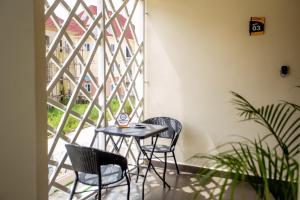 a small table and chairs in a room with a window at Aija Residences in Abuja