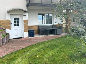 a house with a white door and a bench in a yard at Wohnung in Edermünde in Holzhausen am Hahn