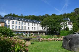 ein großes weißes Gebäude mit einem Garten davor in der Unterkunft Seehotel Maria Laach in Maria Laach