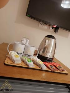 a counter with a coffee maker and cups on it at Antique Pyramids Inn in Giza