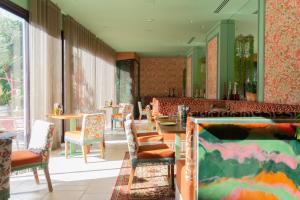 a restaurant with chairs and tables and a mirror at Hôtel Juana in Juan-les-Pins