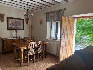 Un comedor con una mesa y sillas y una mesa y una ventana. en Casas Rurales Arcoiris, en Riópar