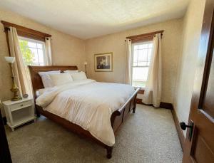 ミラーズバーグにある4BR-Beautiful Historic Homeの大きなベッドと2つの窓がある寝室