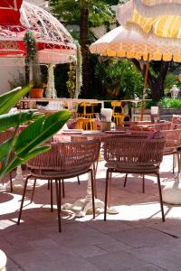 a group of chairs and tables with umbrellas at Hôtel Juana in Juan-les-Pins