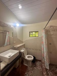 a bathroom with a sink and a toilet and a mirror at Rancho Tranquillo in Moyogalpa +37 photos
