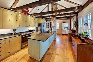 eine große Küche mit Holzschränken und einer großen Insel in der Unterkunft Joy Cottage in Prospect Harbor