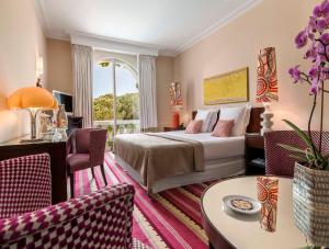 a bedroom with a bed and a living room at Hôtel Juana in Juan-les-Pins