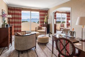 a living room filled with furniture and a living room with a view at Hôtel Juana in Juan-les-Pins