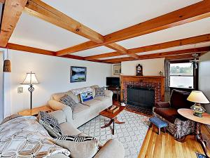 a living room with a couch and a fireplace at Noonie's Nest Waterfront Cottage on Mount Desert Isle in Pretty Marsh