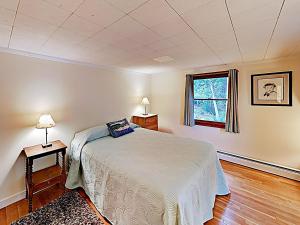 a bedroom with a bed and a window at Noonie's Nest Waterfront Cottage on Mount Desert Isle in Pretty Marsh