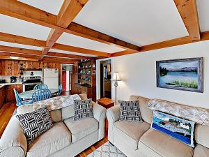 a living room with two couches and a kitchen at Noonie's Nest Waterfront Cottage on Mount Desert Isle in Pretty Marsh