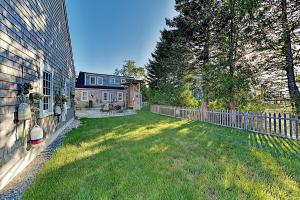 einen Hof mit einem Zaun neben einem Haus in der Unterkunft Joy Cottage in Prospect Harbor