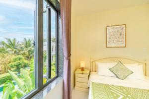 会安The Sunshine Hoi An Villa的一间卧室，里面有一张床和一扇窗户。 更多51张照片