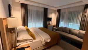 a hotel room with a bed and a couch at Casa Mimosa Hotel in Karaburun