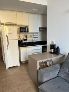a kitchen with a white refrigerator and a counter top at Tasbi House Loft Piratininga in Niterói