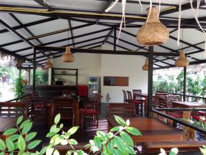 un restaurante con mesas y sillas de madera y luces colgantes en Lucky Gecko Garden en Ko Chang