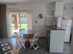 a kitchen with a table and a table and chairs at La casita de duggan in Duggan