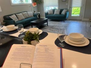 a book on a table with plates and wine glasses at Lido Deck 101 in Old Orchard Beach