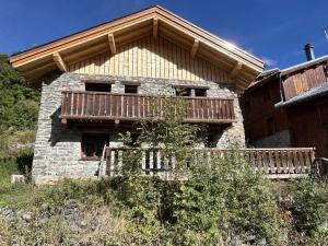 un edificio con un balcone sul lato di Chalet typique 8 personnes à Méribel, calme et pittoresque - FR-1-180-190 a Méribel